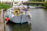 Sailing yacht Puffin 30 (9M) Sloop, 2012, docked near a bridge with Dutch flag.