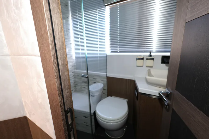  Yacht Photos Pics Bathroom interior of 2019 Galeon 650 Sky yacht with modern fixtures and wooden accents.