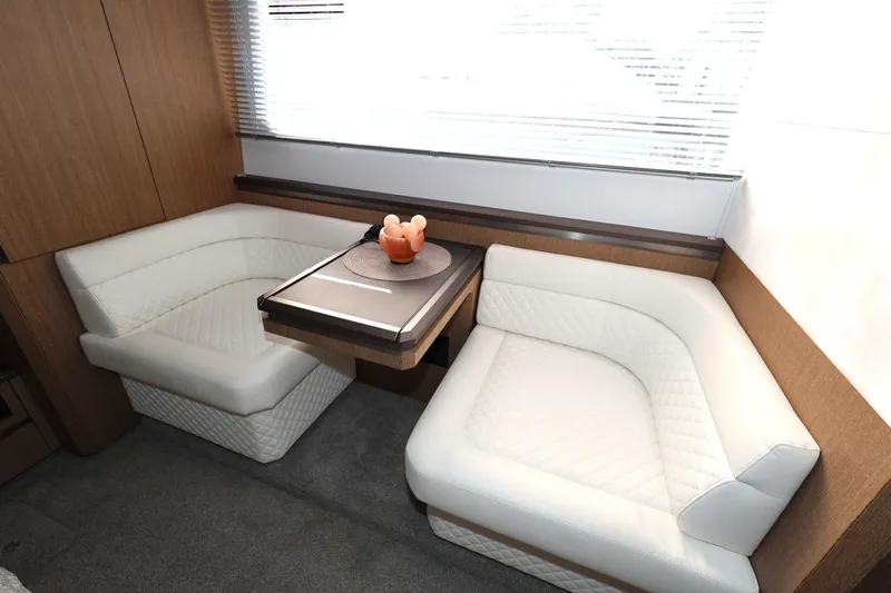  Yacht Photos Pics Luxurious interior of 2019 Galeon 650 Sky yacht with white seating and wooden table.