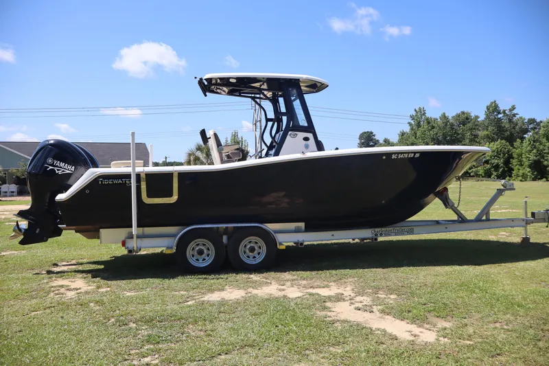  Yacht Photos Pics 2022 Tidewater 272 LXF boat on trailer, side view, outdoors, sunny day.
