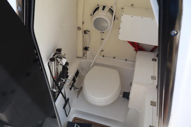  Yacht Photos Pics 2022 Tidewater 272 LXF boat interior with compact marine toilet and storage.