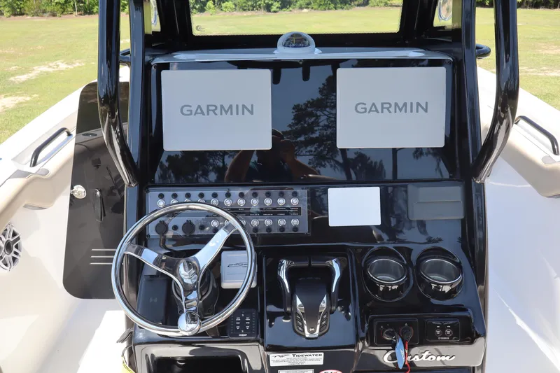  Yacht Photos Pics 2022 Tidewater 272 LXF boat dashboard with Garmin displays and steering wheel.