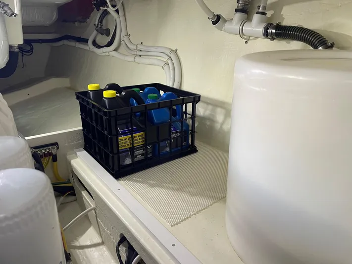 Salty Suite Yacht Photos Pics Engine room of a 2023 Tiara Yachts C44 Coupe with storage crate and equipment.