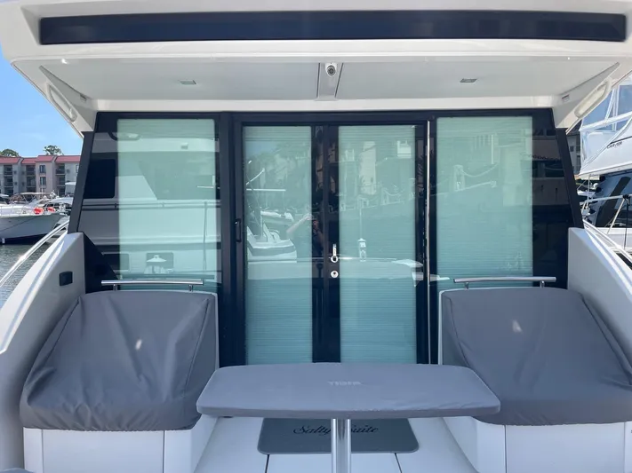Salty Suite Yacht Photos Pics 2023 Tiara Yachts C44 Coupe rear deck with seating and sliding glass doors.
