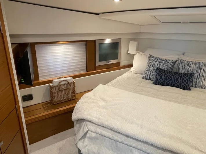 Salty Suite Yacht Photos Pics 2023 Tiara Yachts C44 Coupe bedroom with modern decor and cozy bedding.