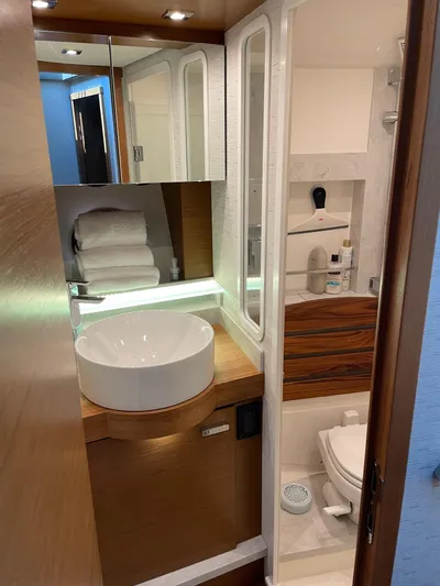 Salty Suite Yacht Photos Pics Modern bathroom in 2023 Tiara Yachts C44 Coupe with sink, mirror, and toilet.