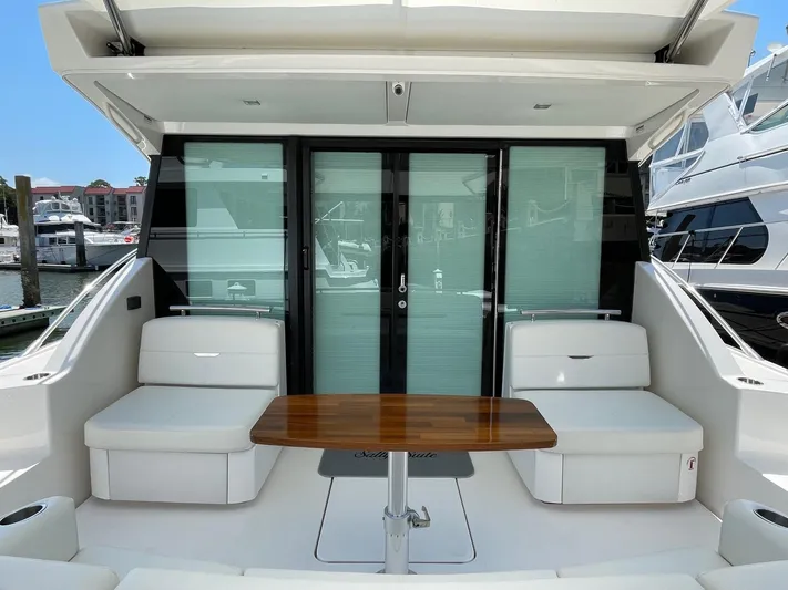 Salty Suite Yacht Photos Pics 2023 Tiara Yachts C44 Coupe rear deck with seating and table.