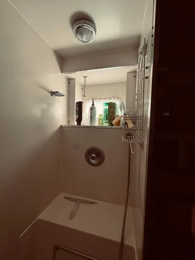 Carol Ann Yacht Photos Pics Shower area in 1984 Hatteras 53 Extended Deckhouse Motor Yacht, featuring storage shelves.