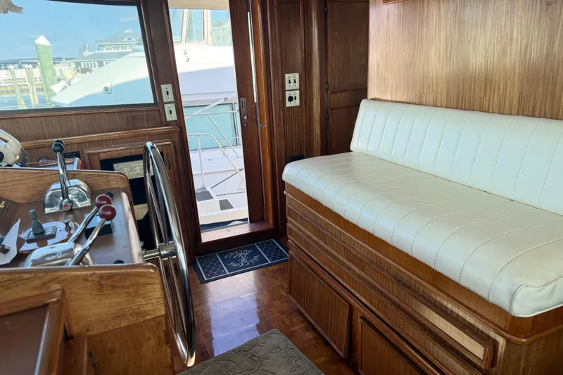 Carol Ann Yacht Photos Pics Interior of 1984 Hatteras 53 Motor Yacht with wooden helm and white seating.