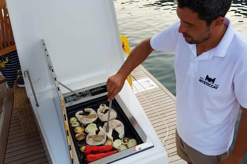  Yacht Photos Pics Man grilling fish and vegetables on a Bali 5.4 yacht, 2019 model.