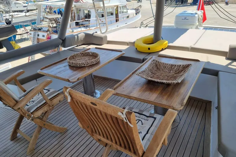  Yacht Photos Pics Outdoor seating area on a 2019 Bali 5.4 yacht with wooden furniture and woven baskets.