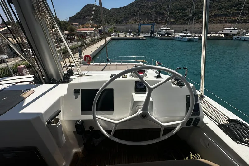  Yacht Photos Pics Steering wheel of a 2019 Bali 5.4 yacht docked in a marina with scenic views.