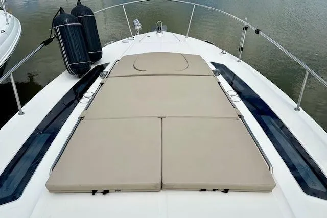  Yacht Photos Pics 2014 Sea Ray 350 Sundancer boat with cushioned sunbathing deck, docked on calm water.