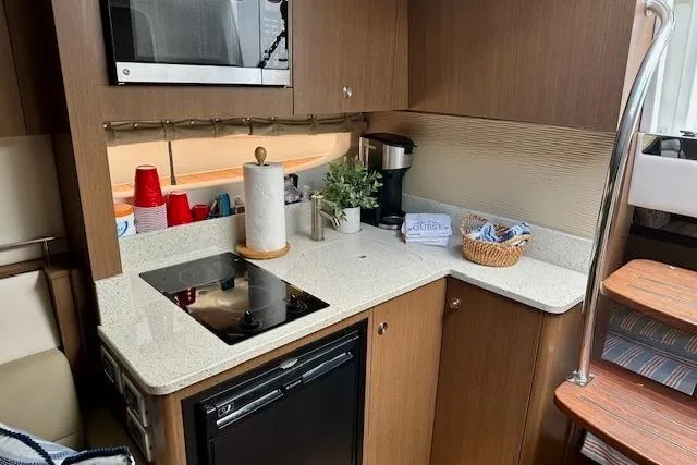  Yacht Photos Pics 2014 Sea Ray 350 Sundancer galley with modern appliances and wooden cabinetry.