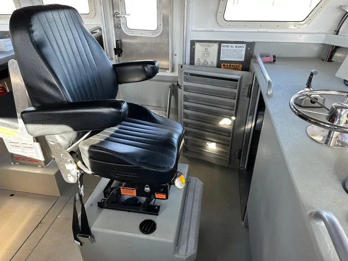  Yacht Photos Pics Captain's chair in 2018 Custom 64 Crew Boat cockpit, featuring control panel and windows.