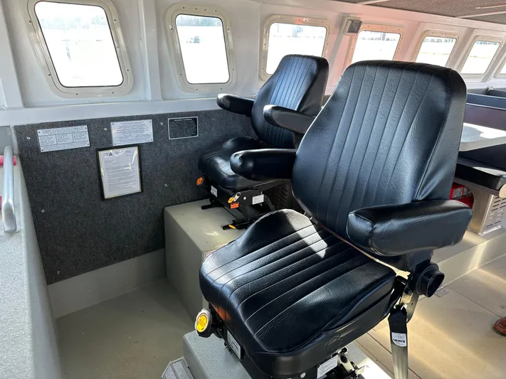  Yacht Photos Pics Two black captain chairs inside a 2018 Custom 64 Crew Boat cabin.