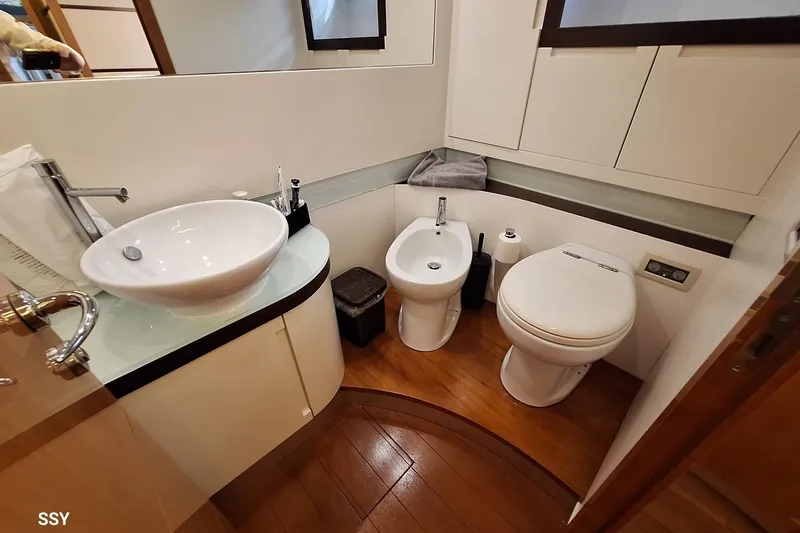 Notorious Yacht Photos Pics Luxurious bathroom in 2005 Pershing 62 HT yacht with modern fixtures and wooden flooring.