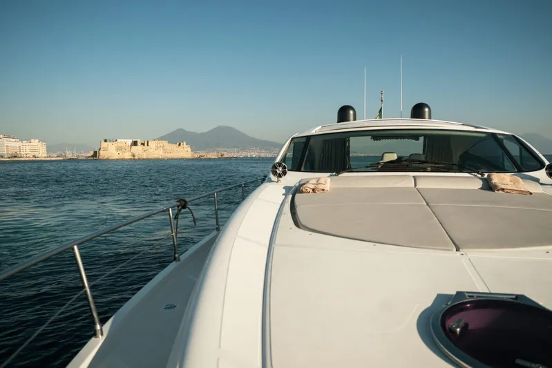 Notorious Yacht Photos Pics 2005 Pershing 62 HT yacht cruising near coastal fortress and mountains.