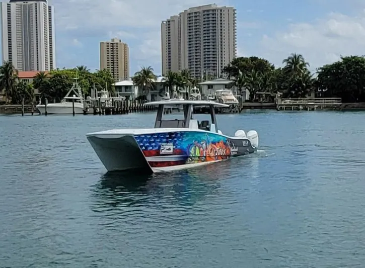  Yacht Photos Pics 2021 Vela 368 Center Console boat with colorful graphics on water near cityscape.