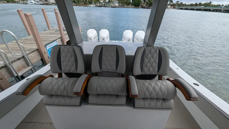  Yacht Photos Pics 2021 Vela 368 Center Console boat with luxurious seating, docked by the water.
