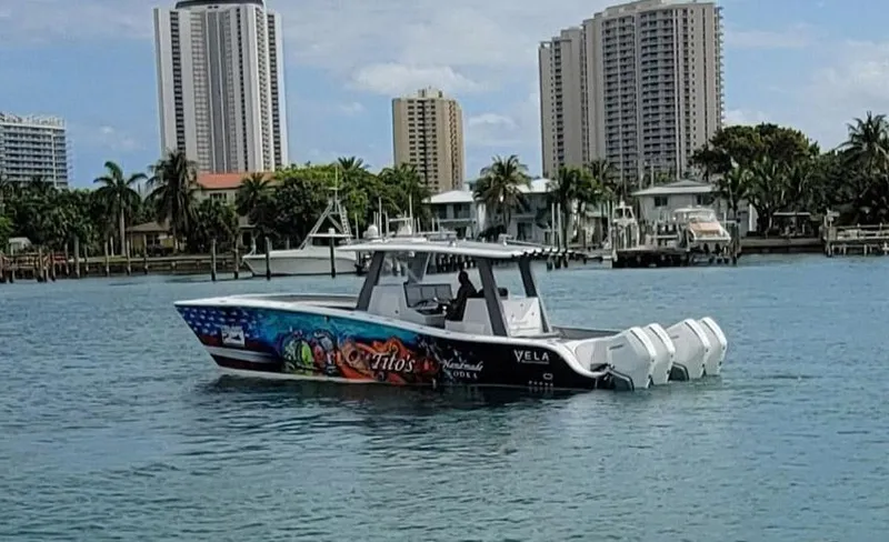  Yacht Photos Pics 2021 Vela 368 Center Console boat on water with city skyline background.