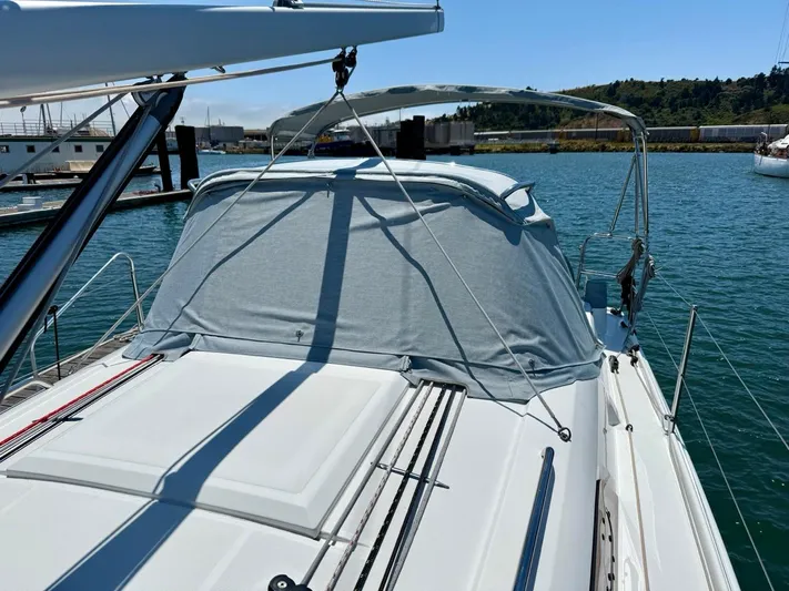 Fasttack Yacht Photos Pics 2024 Beneteau Oceanis 30.1 sailboat docked in a marina, featuring a covered cockpit.