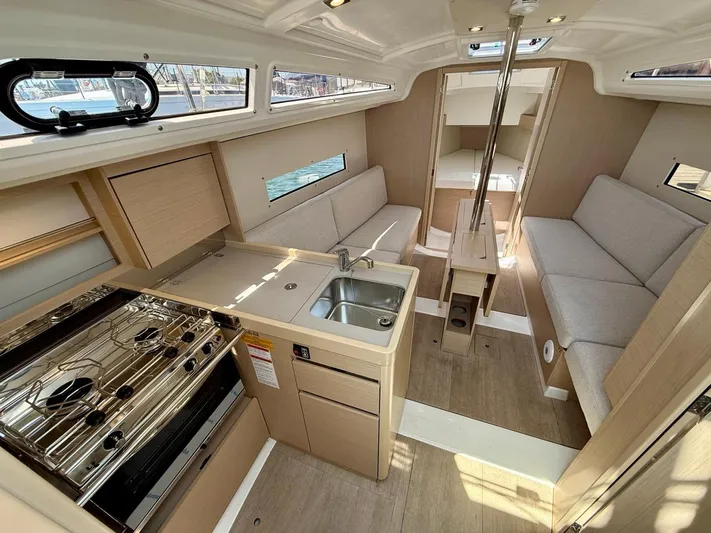 Fasttack Yacht Photos Pics Interior of 2024 Beneteau Oceanis 30.1 sailboat with modern kitchen and seating area.