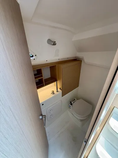 Fasttack Yacht Photos Pics 2024 Beneteau Oceanis 30.1 yacht bathroom with modern fixtures and wooden cabinetry.