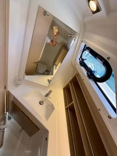 Fasttack Yacht Photos Pics 2024 Beneteau Oceanis 30.1 yacht bathroom with sink, mirror, and window.