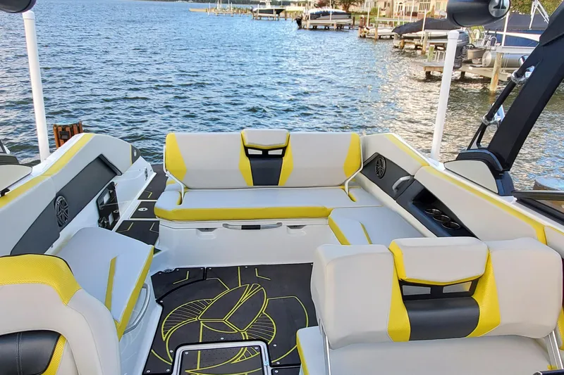  Yacht Photos Pics 2024 Scarab 285 Wake ID boat interior with yellow and gray seating, docked by the water.