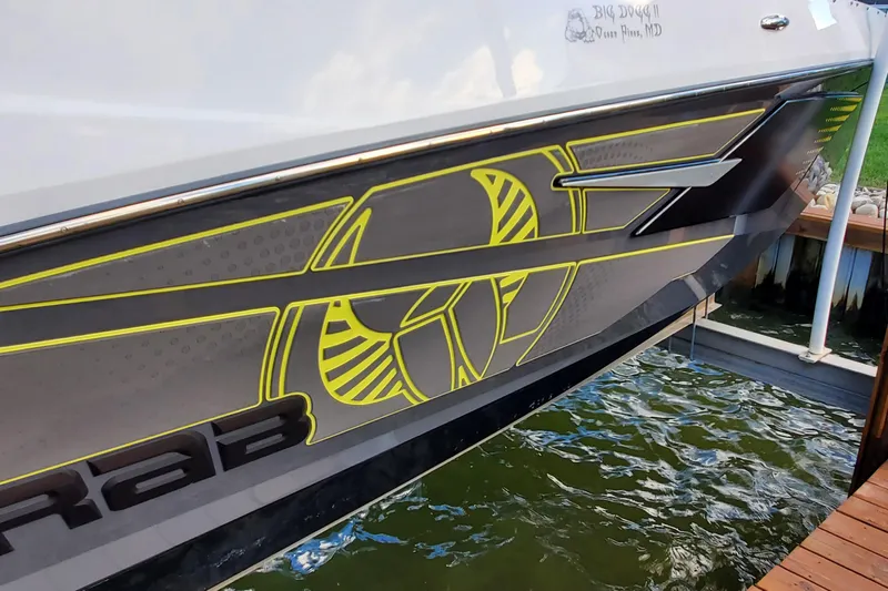  Yacht Photos Pics 2024 Scarab 285 Wake ID boat with sleek graphics docked by the water.