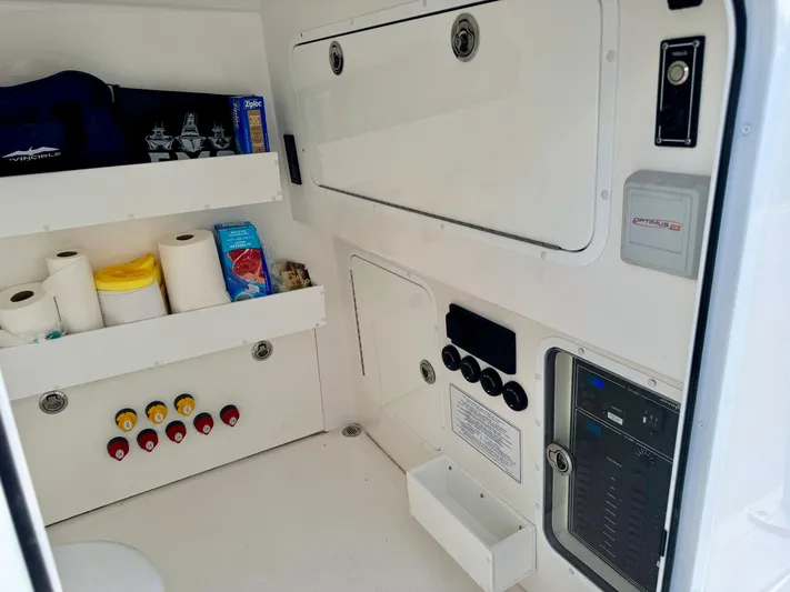 Lulu Yacht Photos Pics Interior of 2020 Invincible 35 Catamaran with storage shelves and control panel.
