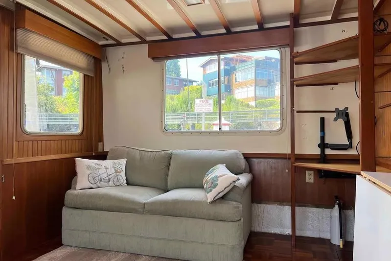 Rhiannon Yacht Photos Pics Interior of 1987 Kadey-Krogen Manatee 36 with sofa, windows, and wooden shelves.