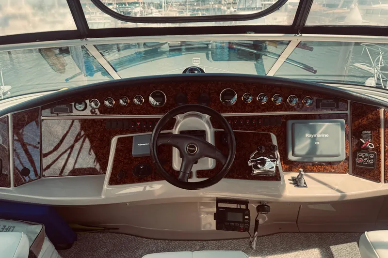 Tom’s Cruise Yacht Photos Pics 2005 Carver 466 Motor Yacht helm with steering wheel, gauges, and Raymarine navigation system.