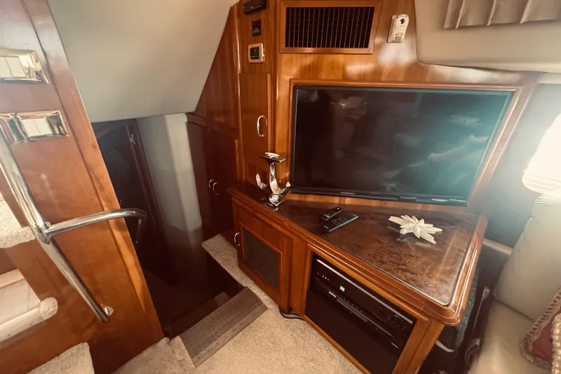 Tom’s Cruise Yacht Photos Pics Interior of 2005 Carver 466 Motor Yacht with TV and wooden cabinetry.