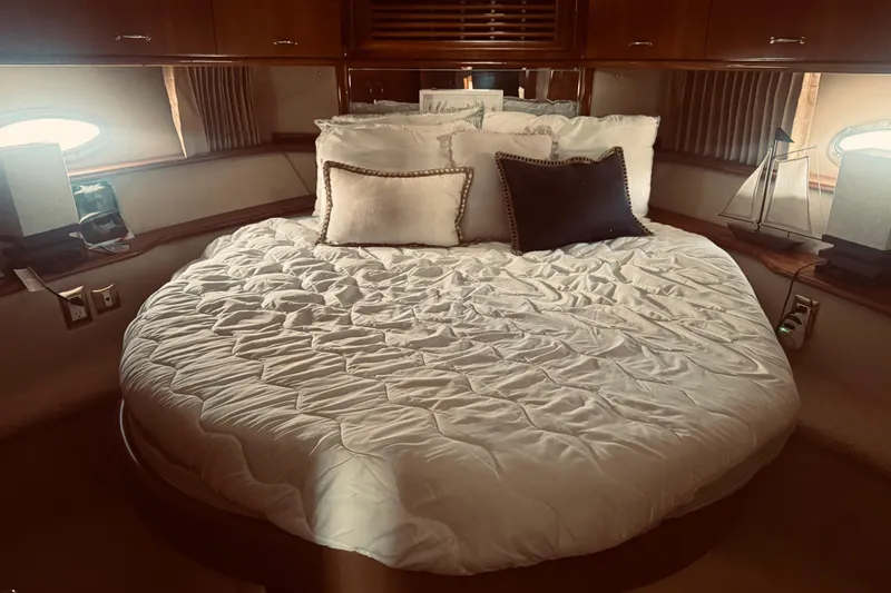 Tom’s Cruise Yacht Photos Pics Luxurious bedroom interior of 2005 Carver 466 Motor Yacht with plush bedding and elegant decor.