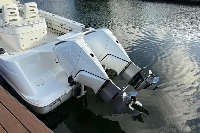 Overdraft Yacht Photos Pics 2005 Boston Whaler 320 Outrage with dual outboard engines docked on calm water.