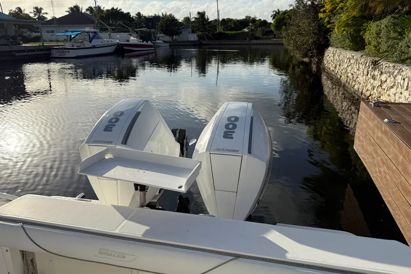 Overdraft Yacht Photos Pics 2005 Boston Whaler 320 Outrage with twin Mercury 300 engines docked by a canal.