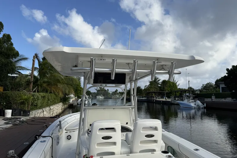 Overdraft Yacht Photos Pics 2005 Boston Whaler 320 Outrage boat docked on a sunny day, surrounded by palm trees.