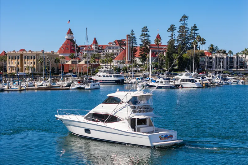 Reel Rodeo Yacht Photos Pics 2014 Maritimo 470 Offshore Convertible yacht cruising near a scenic marina.