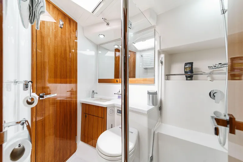 Reel Rodeo Yacht Photos Pics Luxurious bathroom in 2014 Maritimo 470 Offshore Convertible yacht, featuring wood accents and modern fixtures.