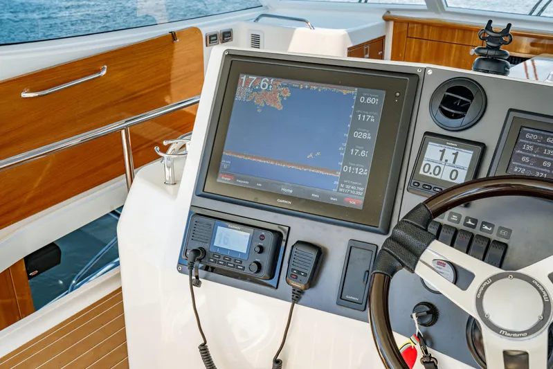 Reel Rodeo Yacht Photos Pics 2014 Maritimo 470 Offshore Convertible helm with navigation equipment and wooden accents.
