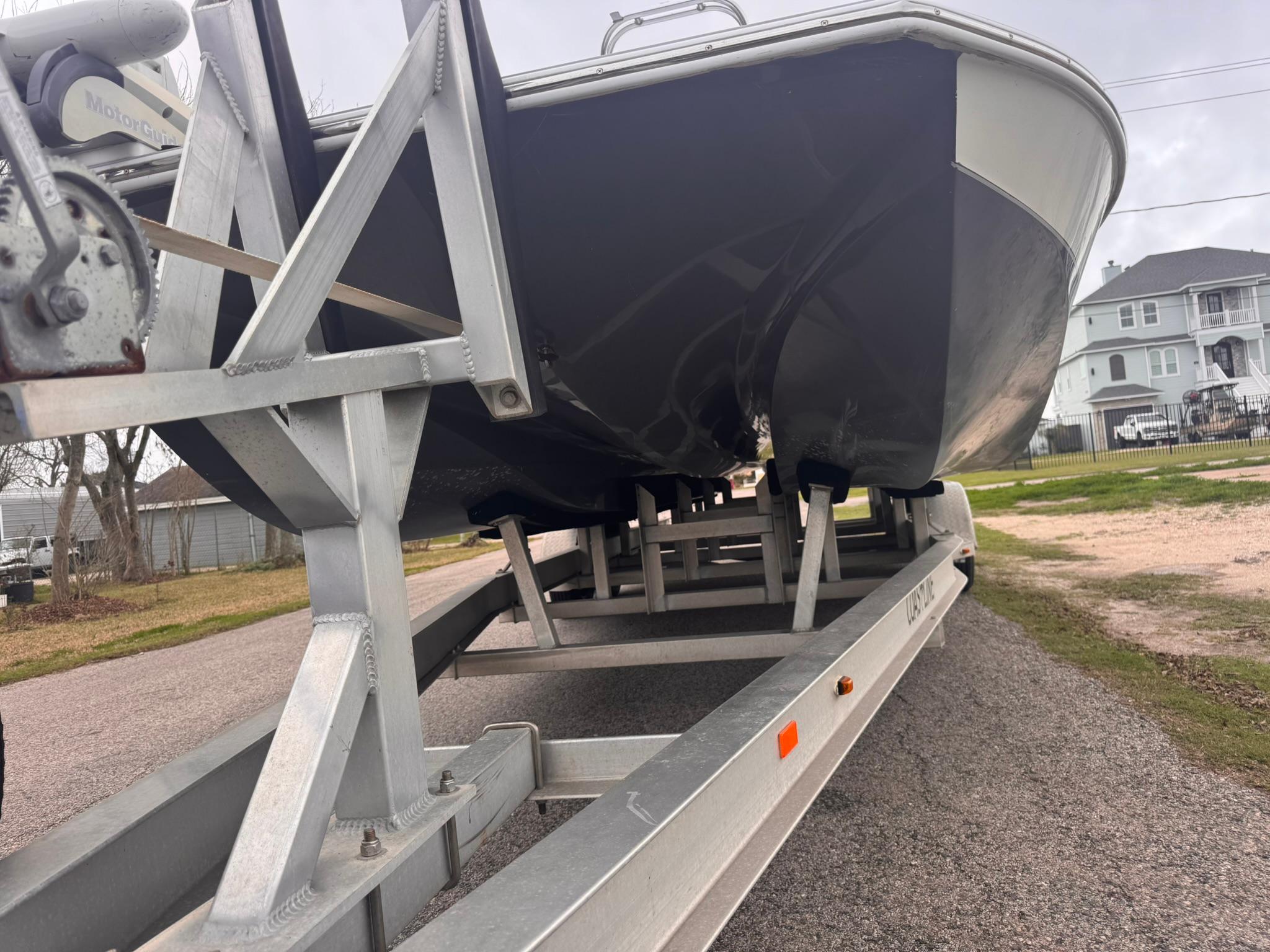 2019 Catalyst 260 Catamaran on trailer, parked outdoors, showcasing hull and trailer structure.