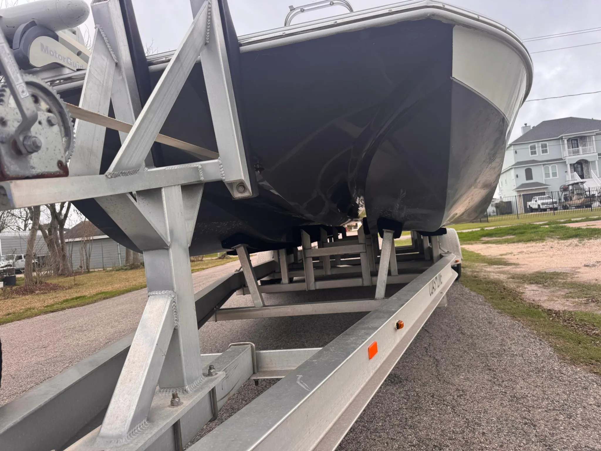 2019 Catalyst 260 Catamaran on trailer, parked outdoors, showcasing hull and trailer structure.