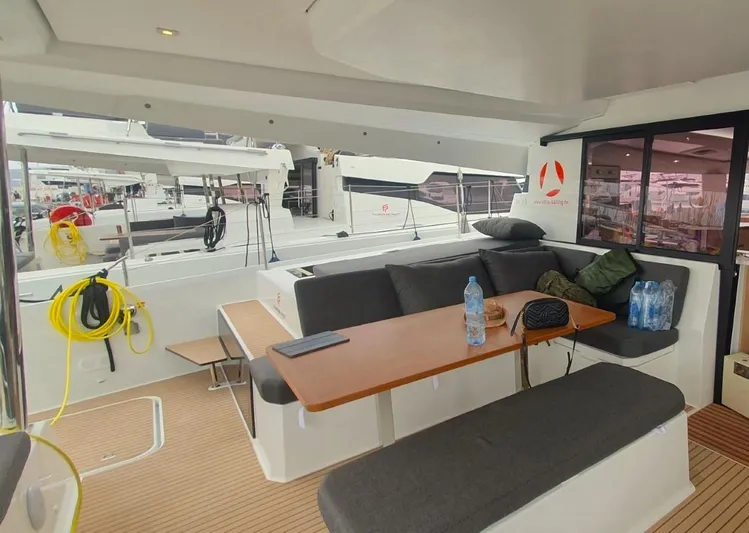  Yacht Photos Pics 2024 Fountaine Pajot Catamaran Elba 45 interior with seating and table, docked at marina.