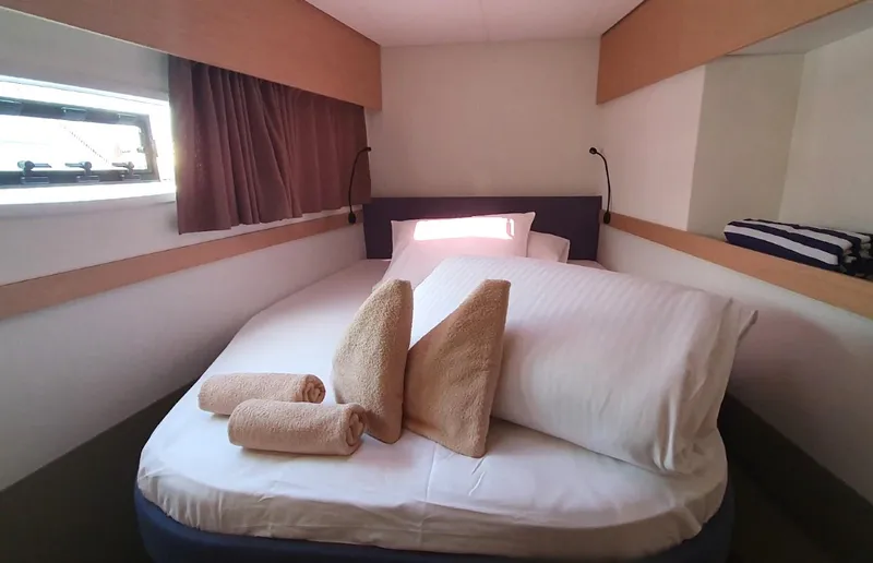  Yacht Photos Pics 2024 Fountaine Pajot Catamaran Elba 45 cabin with cozy bed and rolled towels.