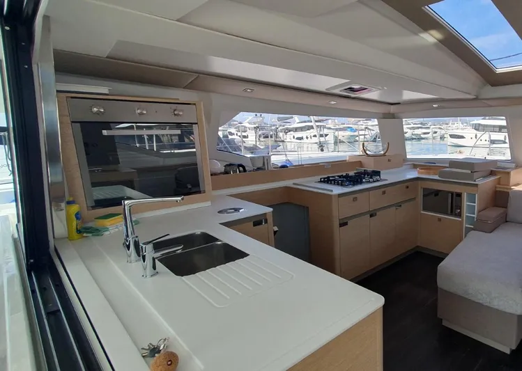  Yacht Photos Pics 2024 Fountaine Pajot Catamaran Elba 45 interior with modern kitchen and marina view.