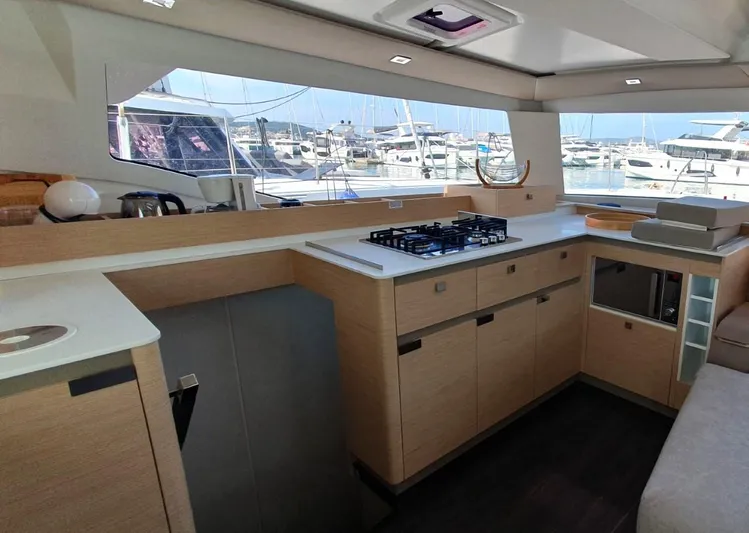  Yacht Photos Pics Modern kitchen interior of 2024 Fountaine Pajot Catamaran Elba 45 with marina view.