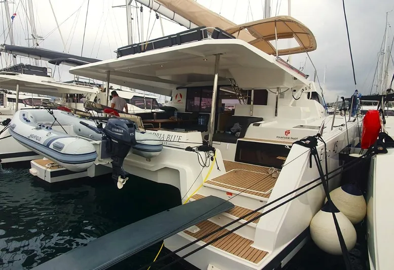  Yacht Photos Pics 2024 Fountaine Pajot Catamaran Elba 45 docked, featuring spacious deck and inflatable dinghy.