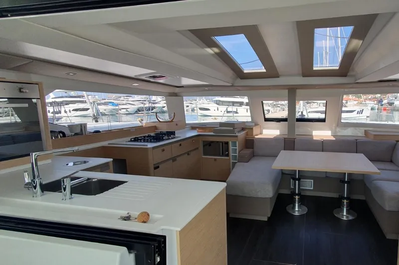  Yacht Photos Pics Luxurious interior of 2024 Fountaine Pajot Catamaran Elba 45 with modern kitchen and seating area.